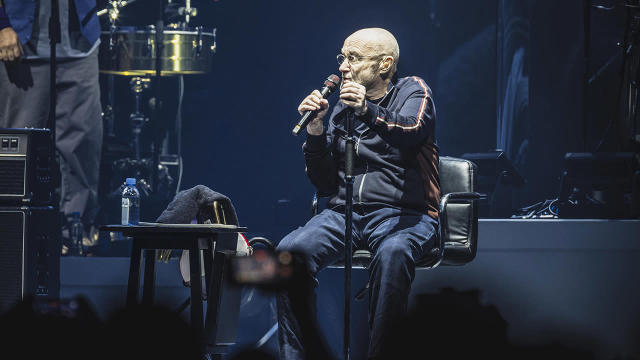 Phil Collins remains seated during Berlin concert after spinal injury